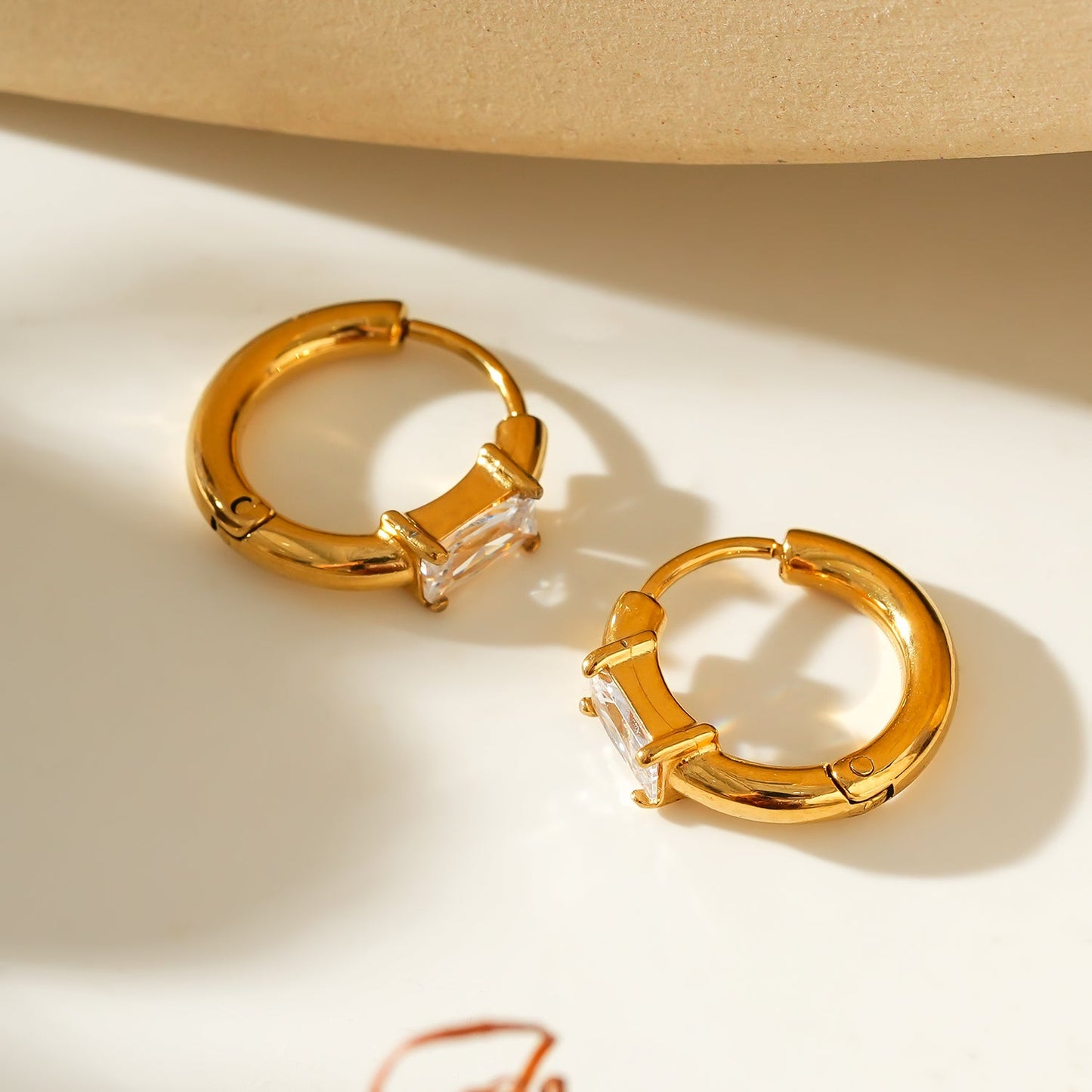 Style CONWYN: Retro Style Hoops with an Encased Clear Zirconia Charm in Gold.