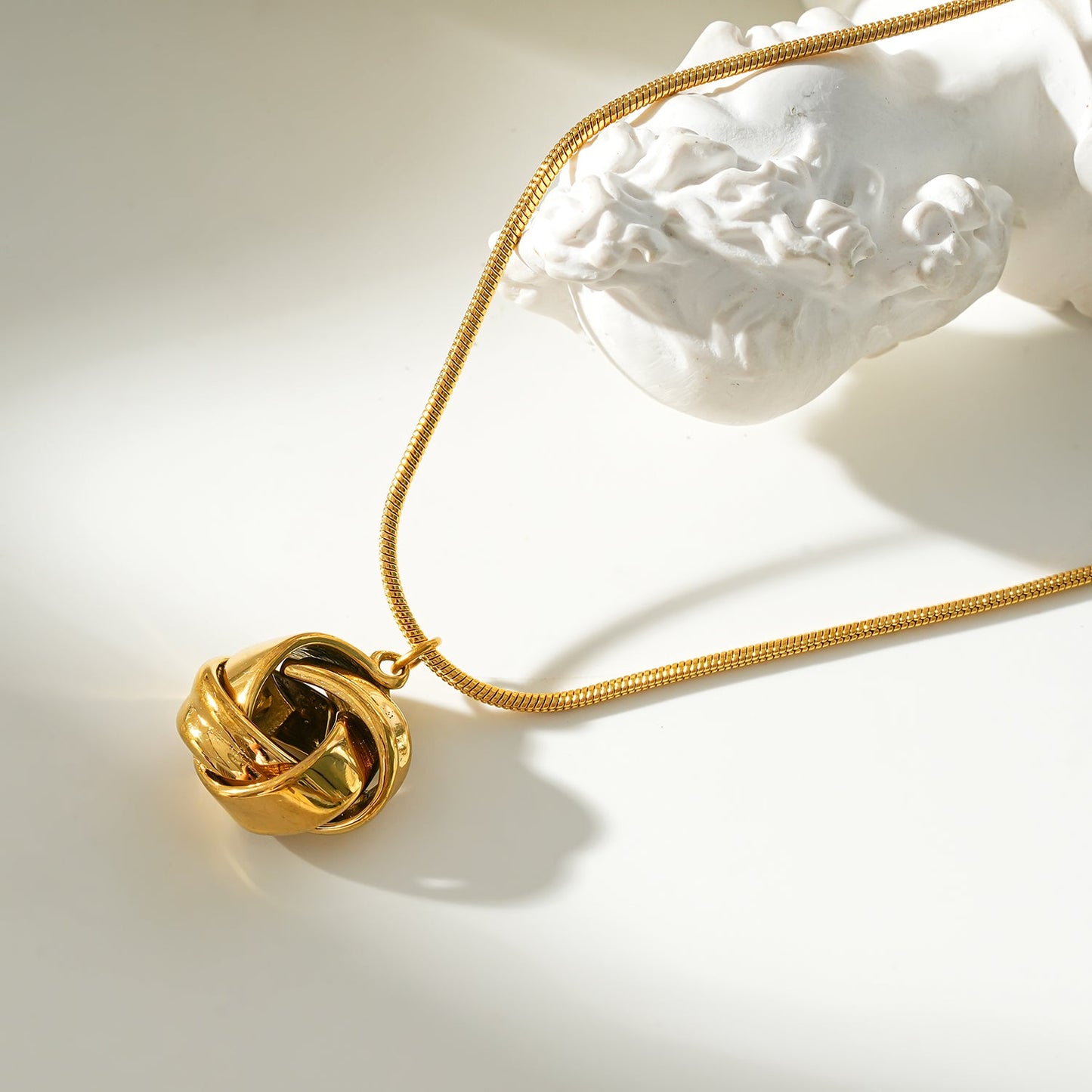 JASPUR: Snakeskin Chain Necklace with Love-Knot Pendant in Gold