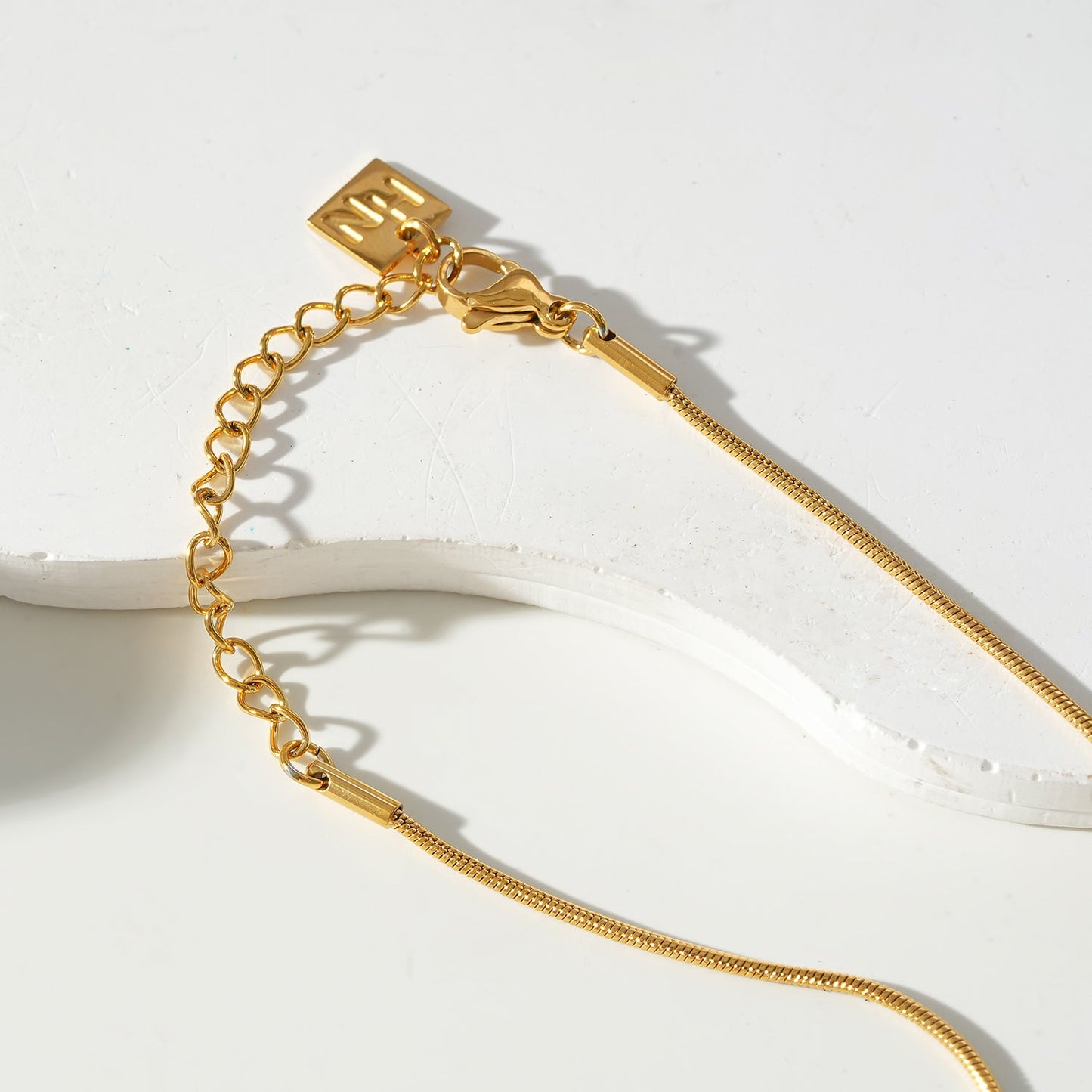 JASPUR: Snakeskin Chain Necklace with Love-Knot Pendant in Gold