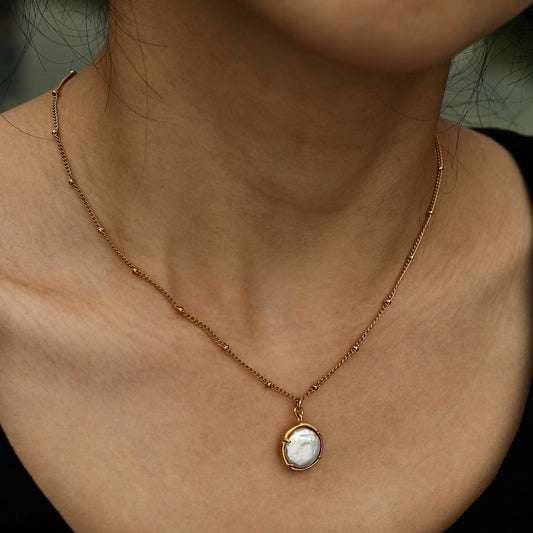 LERATI: Beaded Chain with an Encased Fresh Water Pearl Pendant in Gold