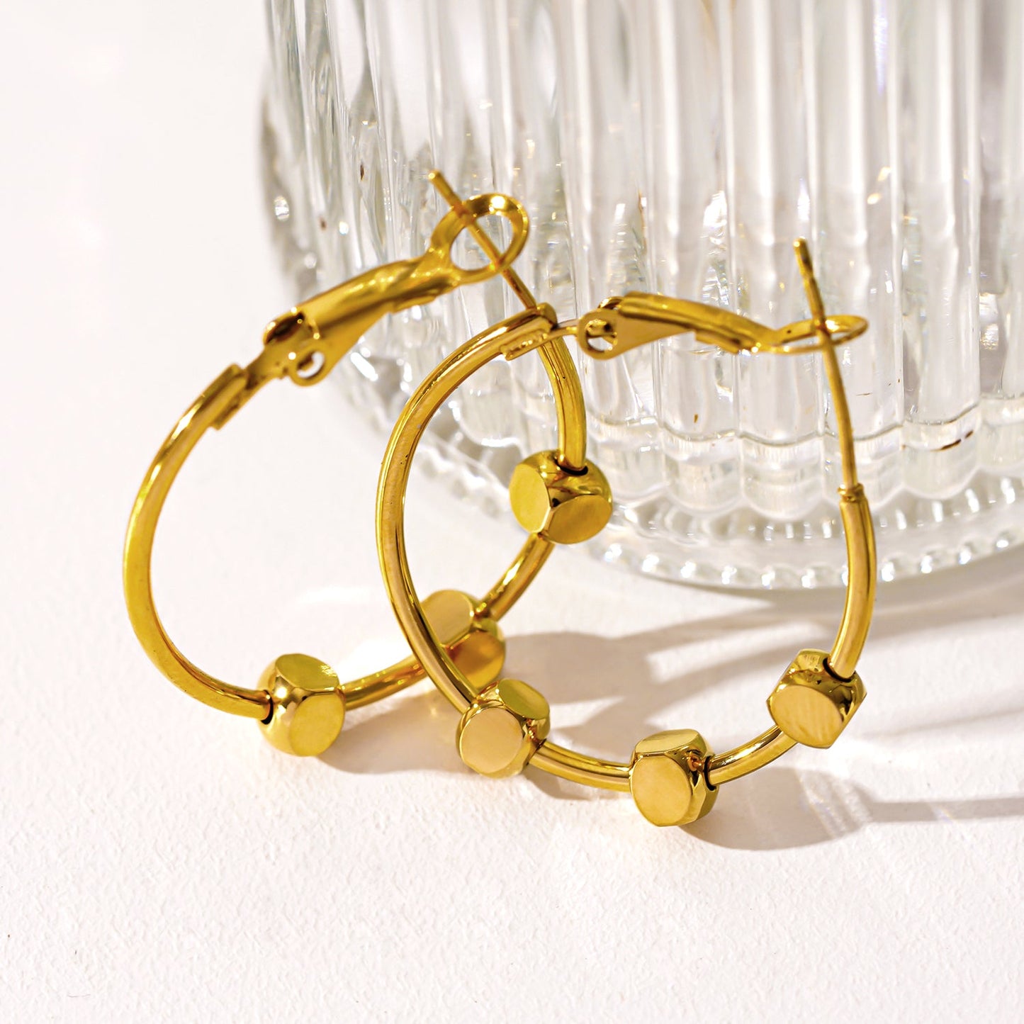 MASUYO: Avant-Garde Rounded Hoop Earrings Anchoring a Trio of Square Beads.