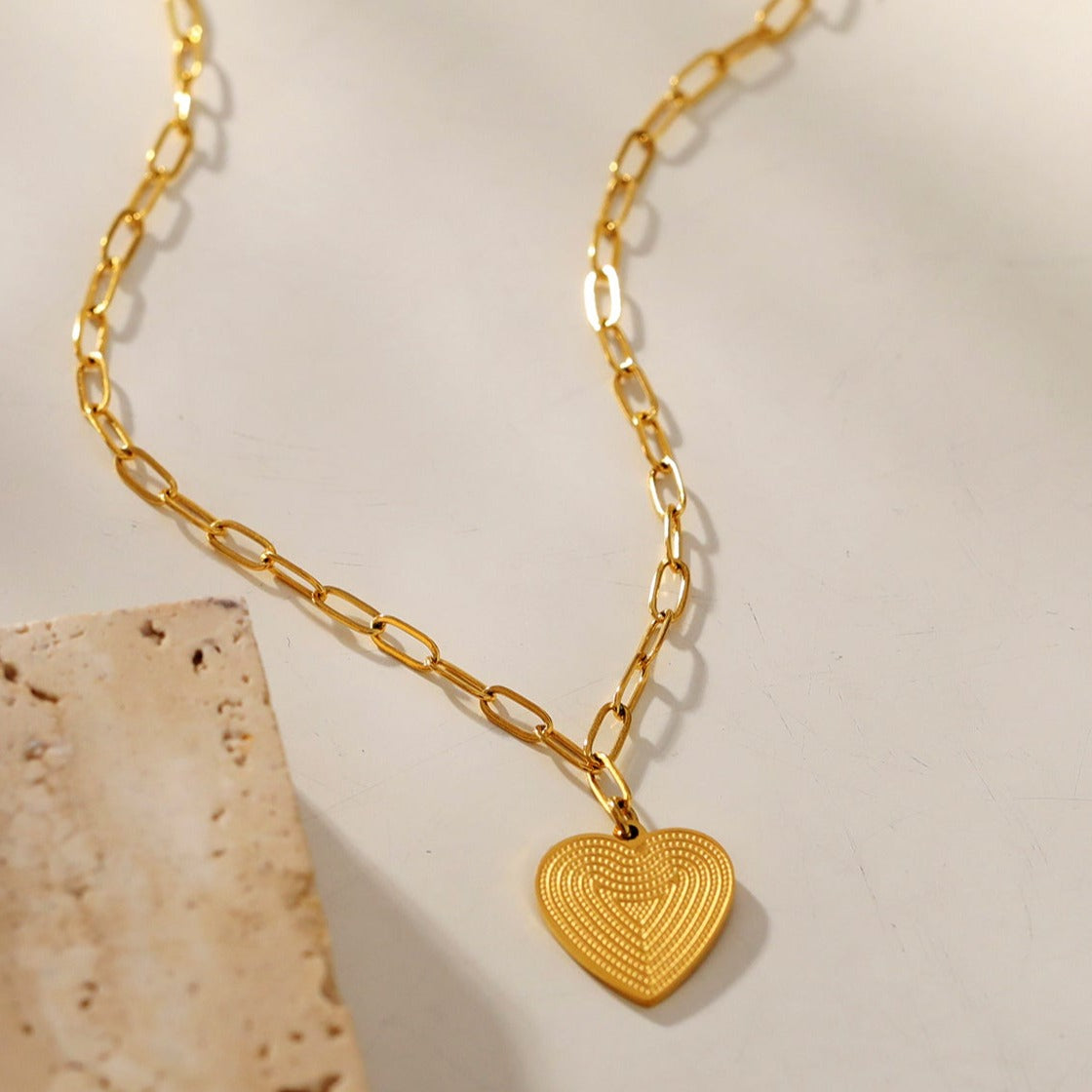 Style ALARA: Mini Paper Clip Chain Anchoring a Patterned Heart Charm in Gold