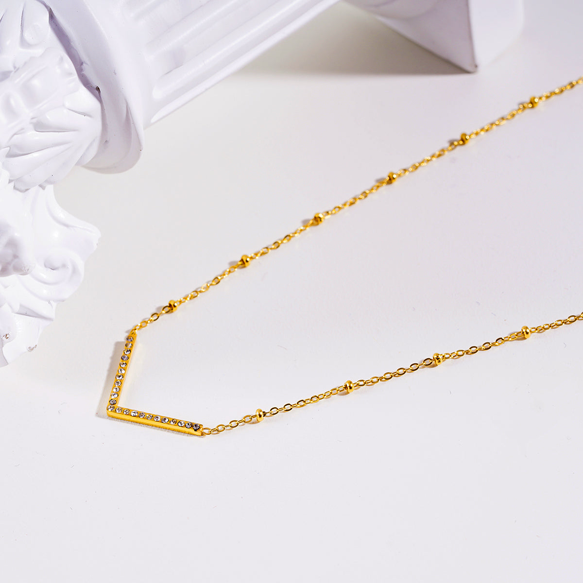 SANITA: Beaded Dainty Chain Anchoring 'V' Shaped Zirconia Embedded Pendant Charm